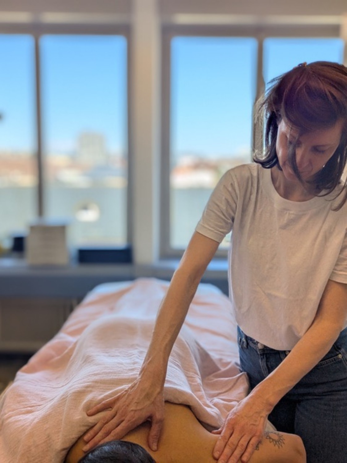 Akupunkteurin führt Tuina Massage an Patientin durch in einer TCM Praxis in Bern